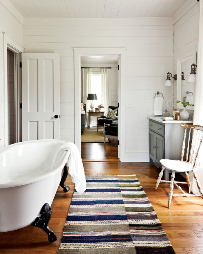 White bath tub with wooden flooring looks heavenly